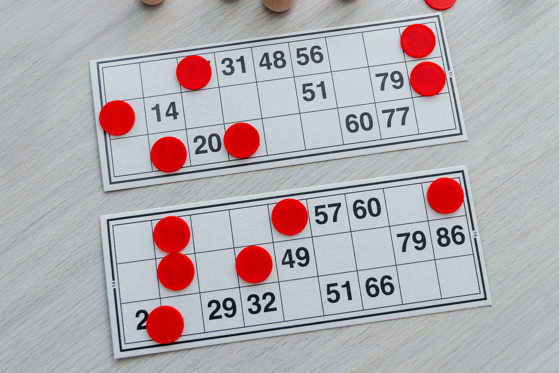 Dos cartones de bingo con sus fichas