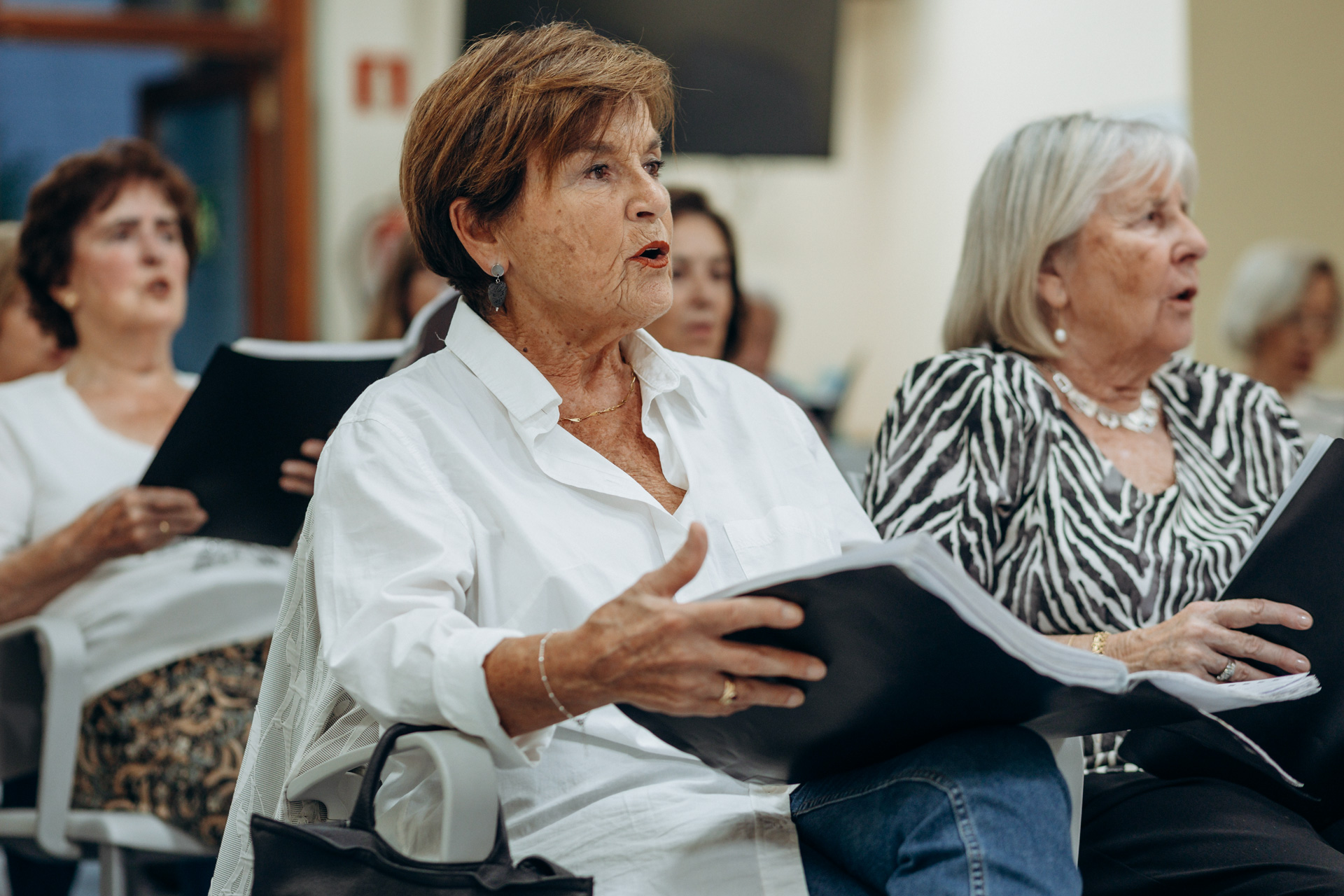 Varias mujeres cantando y sujetando unas partituras