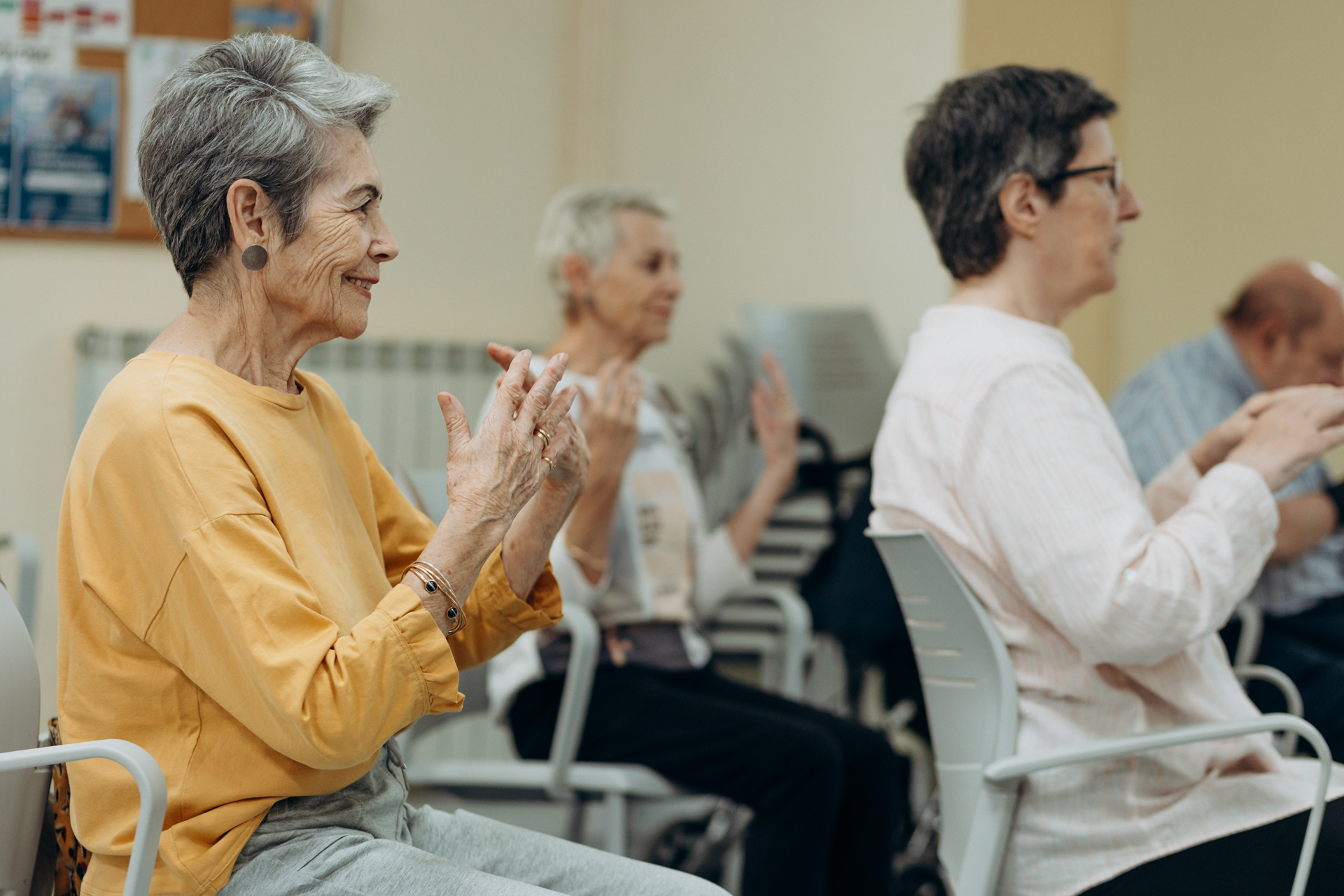 Varias personas sentadas haciendo movimientos con las manos