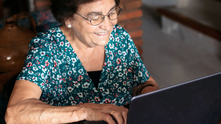 Una mujer sonriendo frente a un ordenador