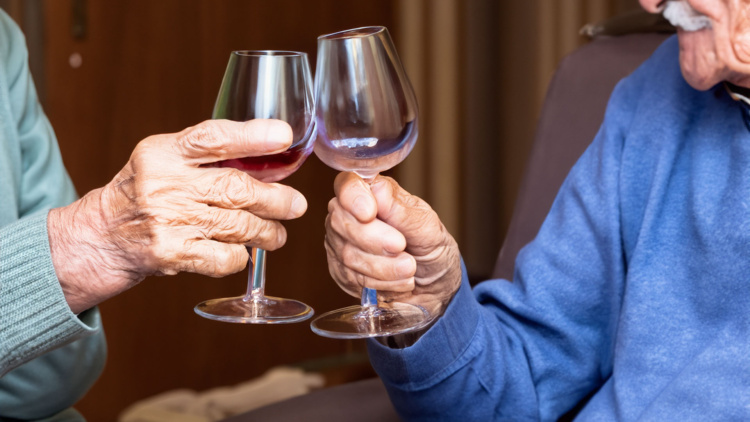 Dos hombres brindando con una copa de vino